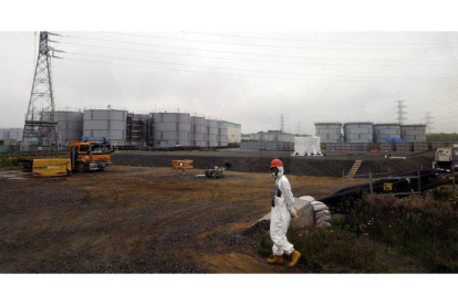 Un trabajador camina cerca de los tanques de agua en la planta nuclear de Fukushima, el pasado mes de junio.