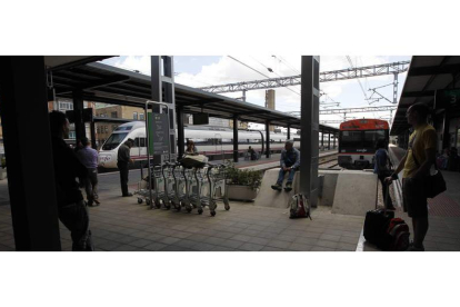 Viajeros y trenes en los andenes de la estación de Adif de León. ARCHIVO
