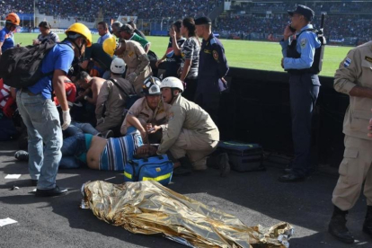 Las asistencias médicas atienden a varios heridos cerca de uno de los dos fallecidos dentro del estadio