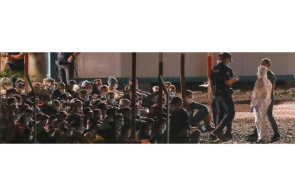 Cientos de personas migrantes llegadas en cayucos a Canarias hacinadas en uno de los muelles de Las Palmas de Gran Canaria. ELVIRA URQUIJO A.