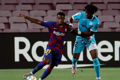 El delantero del Barcelona Ansu Fati juega un balón ante Chidozie Awaziem, del Leganés.  A. ESTÉVEZ