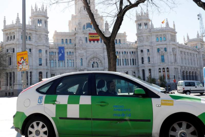 Un vehículo de Medio Ambiente pasa ante la sede del Ayuntamiento de Madrid, ayer.