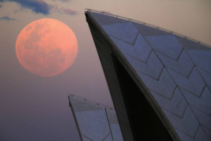 La luna, junto al edificio de la Ópera de Sídney (Australia), este domingo.