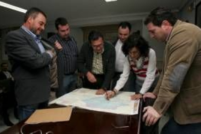 Belén Fernández indica el recorrido en el mapa a los representantes de los municipios participantes