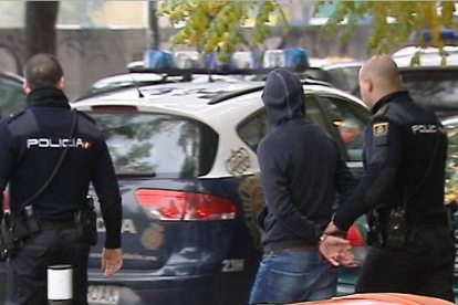 Efectivos de la Policía Nacional conducen a uno de los quince detenidos en la reyerta en Madrid producida entre radicales del Deportivo de La Coruña y del Atlético de Madrid