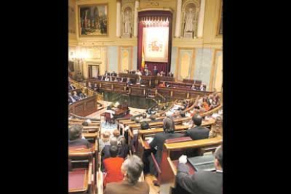 Muchos miembros del Senado han querido presenciar el debate, y la afalta de asientos les ha obligado a quedarse de pie o, como en la imagen, a sentarse en las escaleras.