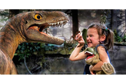 Una niña juega con uno de los animales de la exposición ‘Dinosaurs Tour’, que recalará en León durante dos días. DL