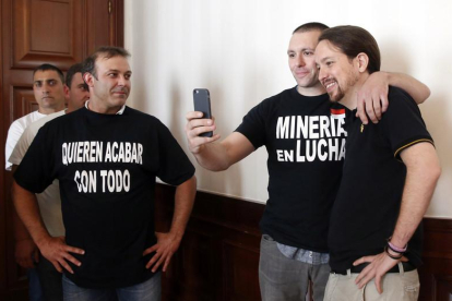 El líder de Podemos, Pablo Iglesias, se hace una foto con un trabajador de Minera Astur-Leonesa antes de la reunión que la formación ha mantenido hoy en el Congreso con trabajadores y representantes del Comité de Empresa de la compañía minera.
