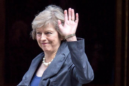 La ministra del Interior británica, Theresa May, saluda a los medios a su llegada a Downing Street para asistir al último consejo de ministros con David Cameron como anfitrión en Westminster, en el centro de Londres.