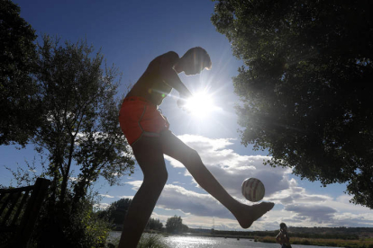 Un joven juega a la pelota al lado del río en Santa Marina del Rey, ayer. JESÚS F. SALVADORES