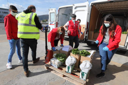 Voluntarios de Cruz Roja recogen los lotes de comida, ayudados por un trabajador del BAS. ANA F. BARREDO