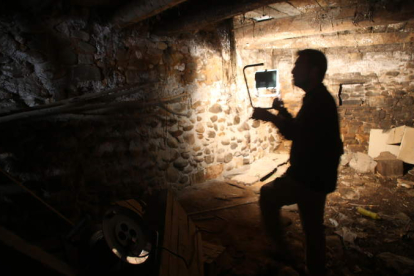 El arqueólogo forense de la ARMH, René Pacheco, iluminaba ayer con un foco el lugar donde enterraron a Claudio Macías en la bodega de su casa de Villalibre