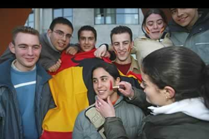 Unos jóvenes pintan sus caras con los colores de la selección española antes del inicio del encuentro.