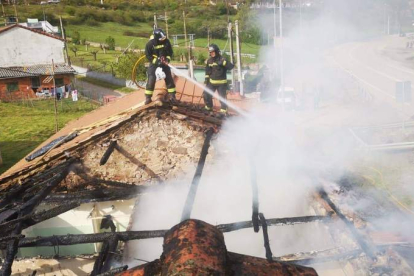Dos bomberos actúan en el tejado del edificio siniestrado. BOMBEROS DE LEÓN