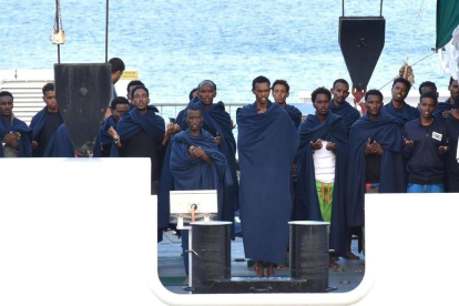 Un grupo de personas reza a bordo del Diociotti, atracado desde hace unos días en el puerto de Catania (Sicilia).