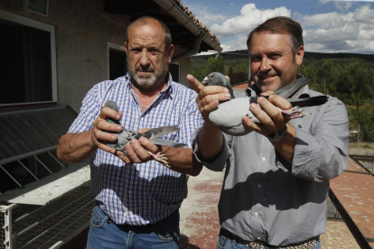 Juan Carlos Gutiérrez y Fernando González con dos palomas mensajeras en Pardavé de Torío. RAMIRO