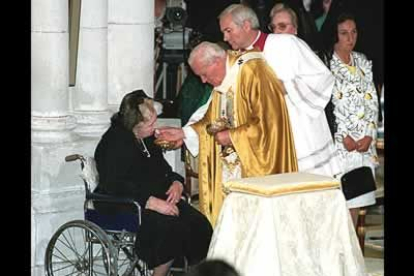 En su tercera visita a España, el Papa da el sacramento de la Comunión a Doña María de las Mercedes de Borbón y Orleáns, durante la ceremonia de consagración de la Catedral de la Almudena, en Madrid.