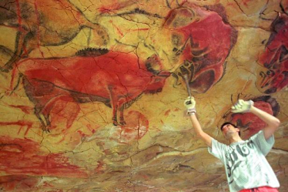 Un operario repara la reproducción de una de las pinturas que se encuentran en la cueva de Altamira.