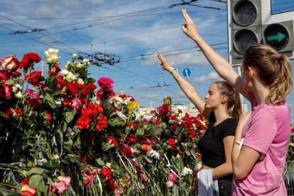 Dos mujeres hacen el signo de la victoria en el lugar donde falleció un manifestante. TATYANA ZENKOVICH
