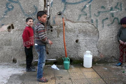 Varios niños hacen acopio de agua en la ciudad siria de Duma, cerca de Damasco.