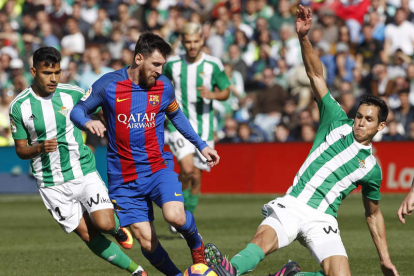 El argentino Leo Messi intenta zafarse del férreo marcaje de dos jugadores del Betis. JULIO MUÑOZ