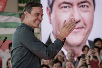 Pedro Sánchez aplaude ante un retrato del candidato Juan Espadas ayer, en Sevilla. JULIO MUÑOZ