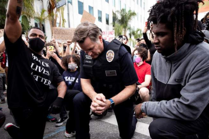 Imagen de un policía arrodillado como muestra de respeto ante las protestas en Los Angeles. ETIENNE LAURENT