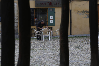 Un camarero limpia la mesa de una terraza de la Plaza del Grano. FERNANDO OTERO