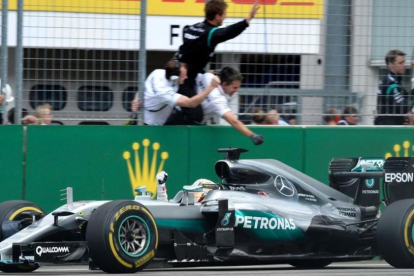Hamilton celebra el triunfo en Alemania al paso frente a sus mecánicos.