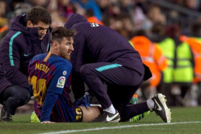 Messi recibe un masaje en el muslo derecho tras quejarse de unas molestias en la segunda mitad del Barça-Valencia.