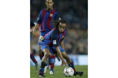 Ronaldinho observa como Davids prepara el lanzamiento de una falta