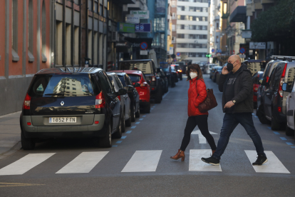 Dos personas caminan por la calle Alfonso V de León. RAMIRO