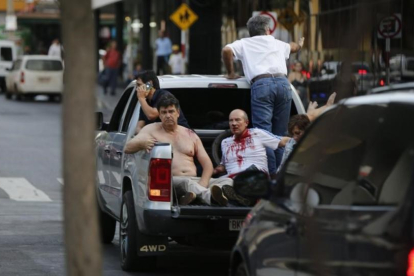 Efraín Alegre, líder del Partido Liberal (izquierda), junto a un herido en los disturbios de la madrugada del sábado en Asunción.