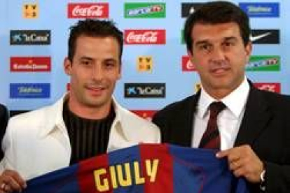 Giuly, a la izquierda, sostiene la camiseta con su nombre, junto al presidente barcelonista Laporta