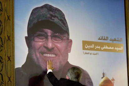 Adnan Badriddine toca la foto del su hermano, Mustafa, en el homenaje al jefe militar de Hizbolá en El Líbano.