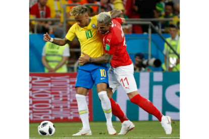 El brasileño Neymar es frenado por el futbolista suizo Valon Behrami. SHAWN THEW