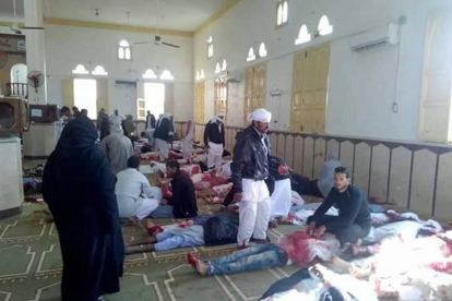 Varias personas permanecen junto a cuerpos sin vida en el interior una mezquita contra la que se ha perpetrado un ataque, en la ciudad de Al Arish, en el norte de la península del Sinaí.