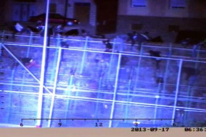 Fotografía facilitada por la Guardia Civil de varios inmigrantes, en total, más de un centenar, saltando la valla de Melilla, ayer sobre las 06.30 horas de la mañana en la zona comprendida entre los pasos fronterizos de Barrio Chino y Beni Enzar.