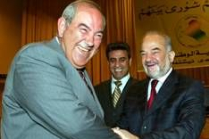 El primer ministro saliente, Iyad Alawi (a la izquierda) saluda a su sucesor, Ibrahim al Yafari