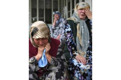 Dos mujeres lloran la pérdida de sus seres queridos.