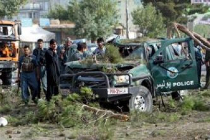 Miembros de la Policía afgana revisan los daños tras la explosión.
