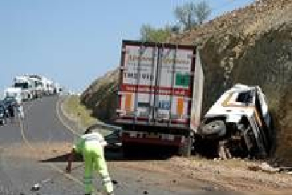 Un operario limpia la carretera N-234 junto al camión que se vió involucrado ayer en un accidente