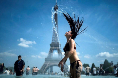 Una mujer se refresca en las fuentes de la explanada de Trocadero, en París. / KENZO TRIBOUILLARD (AFP)