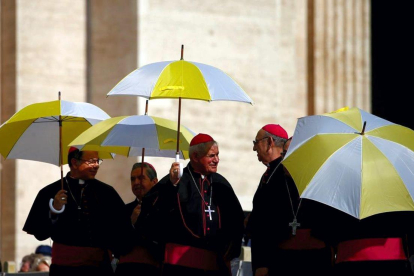 Miembros del clero se resguardan del sol con paraguas en la plaza de San Pedro, en El Vaticano. / YARA NARDI (REUTERS)
