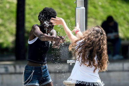 Niños juegan con agua en la plaza de Estalingrado, en París. / KENZO TRIBOUILLARD (AFP)