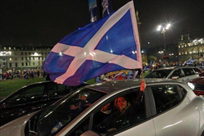 Partidarios de la independencia agitan una bandera de Escocia en el centro de Glasgow.
