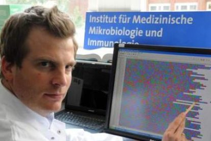 El bacteriólogo Rohde señala una parte de la decodificación del genoma de la bacteria 'E-coli'.