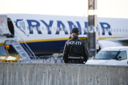 Un agente de policía, frente al avión de Ryanair evacuado, el domingo en el aeropuerto noruego de Moss-Rygge.