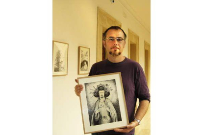 El artista leonés Karlos Viuda porta una de las obras que expone en la Casa de Carnicerías.