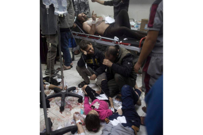 Un hombre llora con sus dos hijos heridos en el suelo del último hospital del norte de Gaza. HAITHAM IMAD